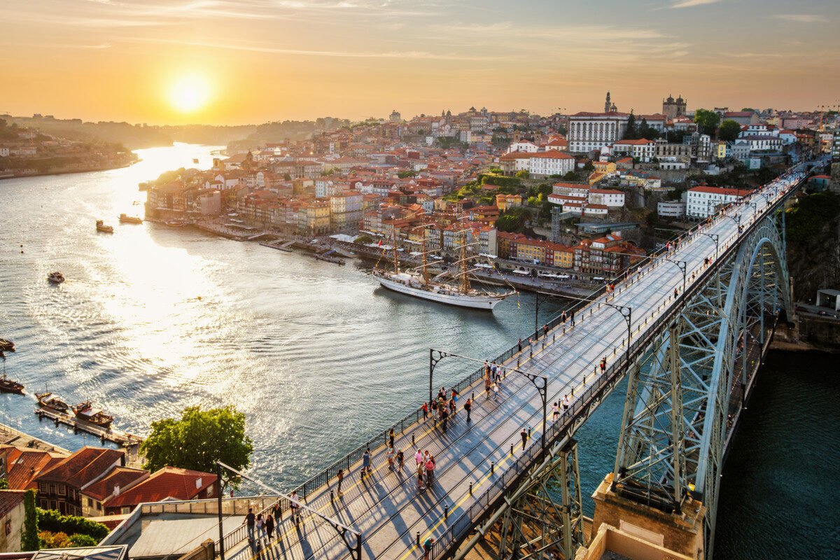 Moving to Portugal from the USA 5 Sunset view over Porto city and the Douro River, highlighting the historic Ribeira district.